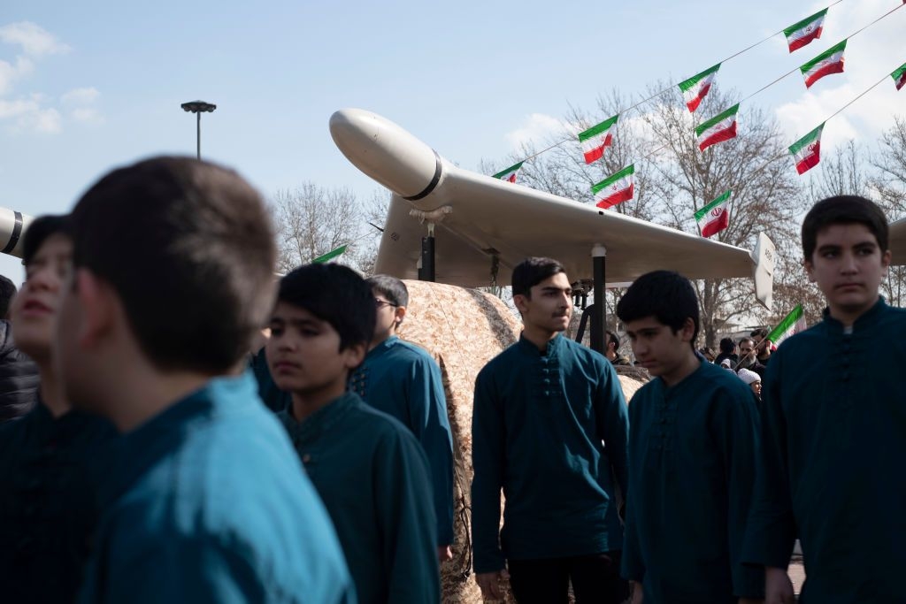 Iranian youth stand under an Iranian-made Shahed-136 unmanned aerial vehicle in Tehran, Iran, on Feb. 11, 2023. 