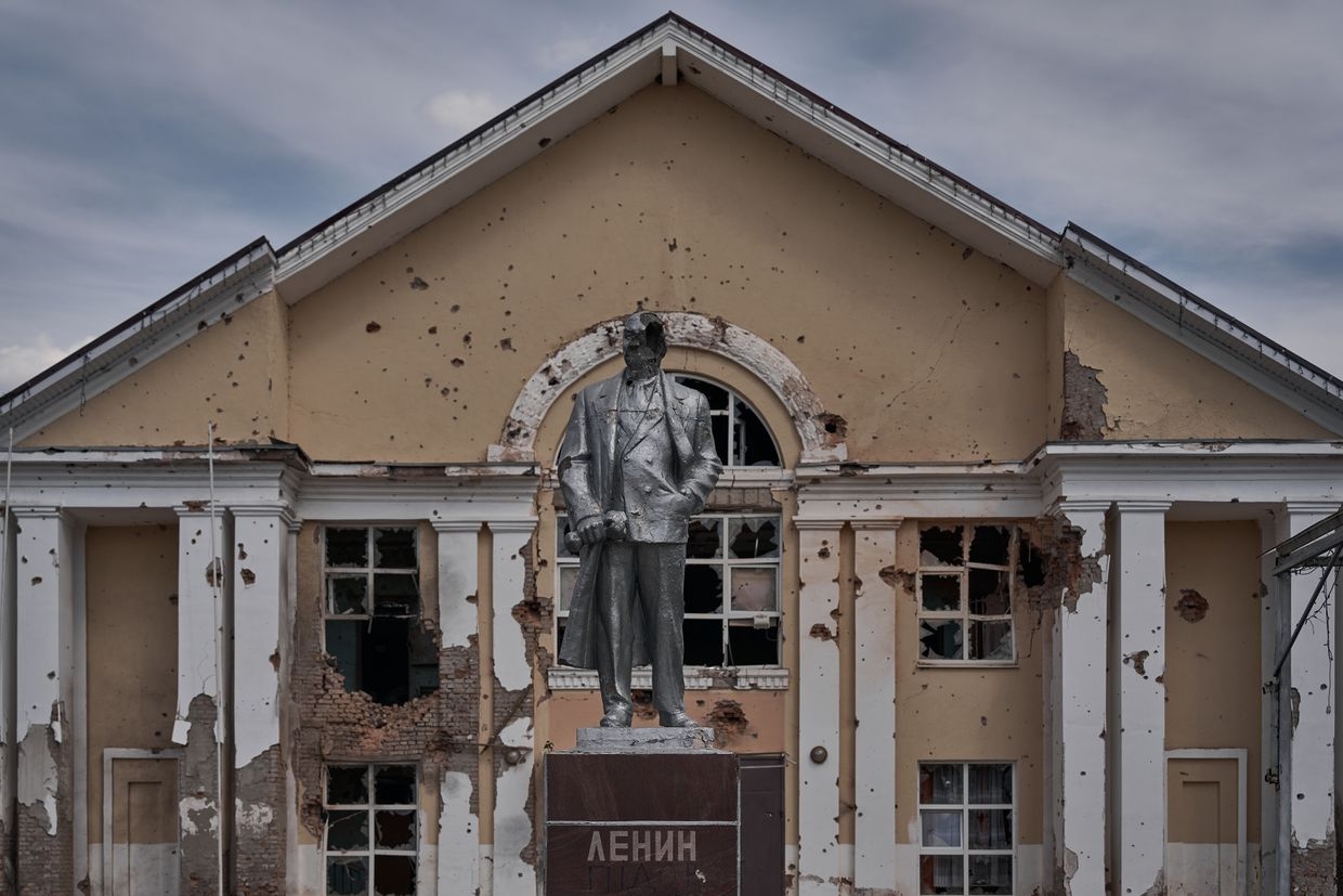A damaged statue of Vladimir Lenin, the first head of the Soviet state, stands in front of a building in Sudzha, Russia