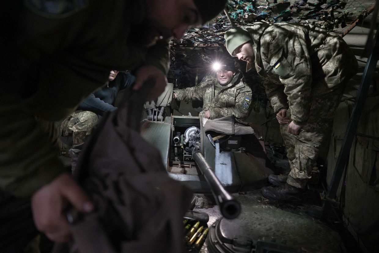 Ukrainian servicemen install an automatic cannon after preventive maintenance on an armored military vehicle at a workshop in the Donetsk Oblast, Ukraine