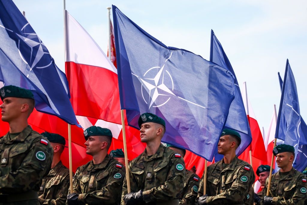 Soldiers carry flags of NATO and flags of the Republic of Poland during a military parade on Polish Armed Forces Day in Warsaw, Poland on Aug. 15, 2024. 