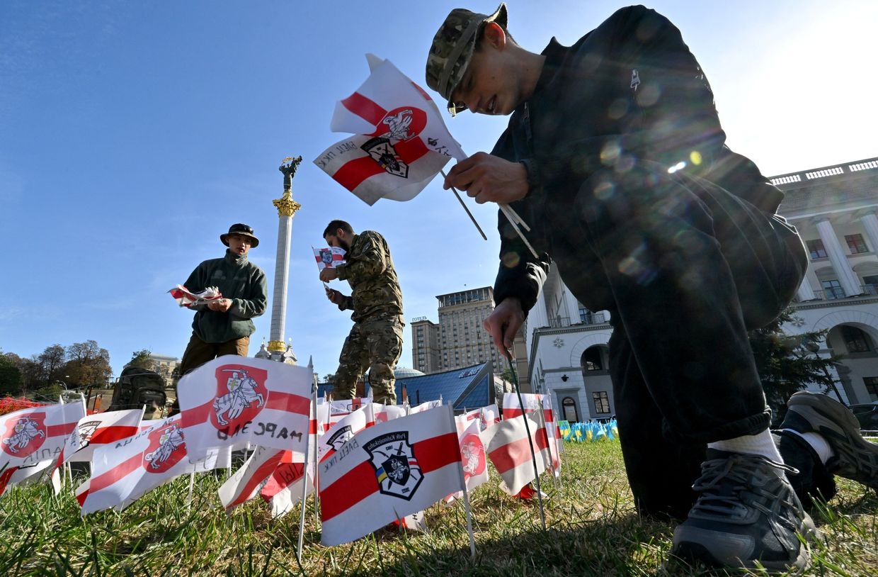  Servicemen of the Volat Battalion, part of the Belarusian Kastus Kalinouski Regiment, plant flags at Independence Square in Kyiv on Oct. 12, 2023.