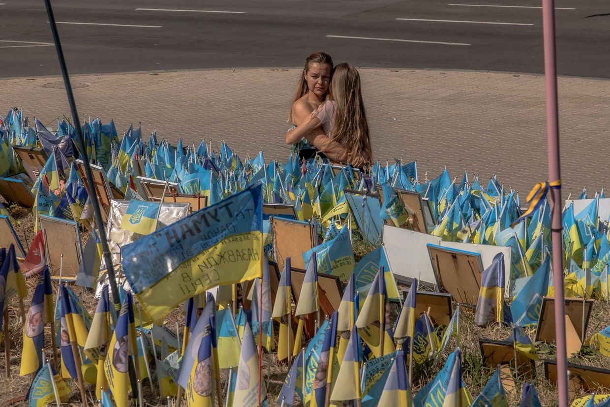 Women embrace each other as they visit a designated area for commemorating fallen Ukrainian and foreign fighters in Kyiv, Ukraine on Aug. 24, 2024.