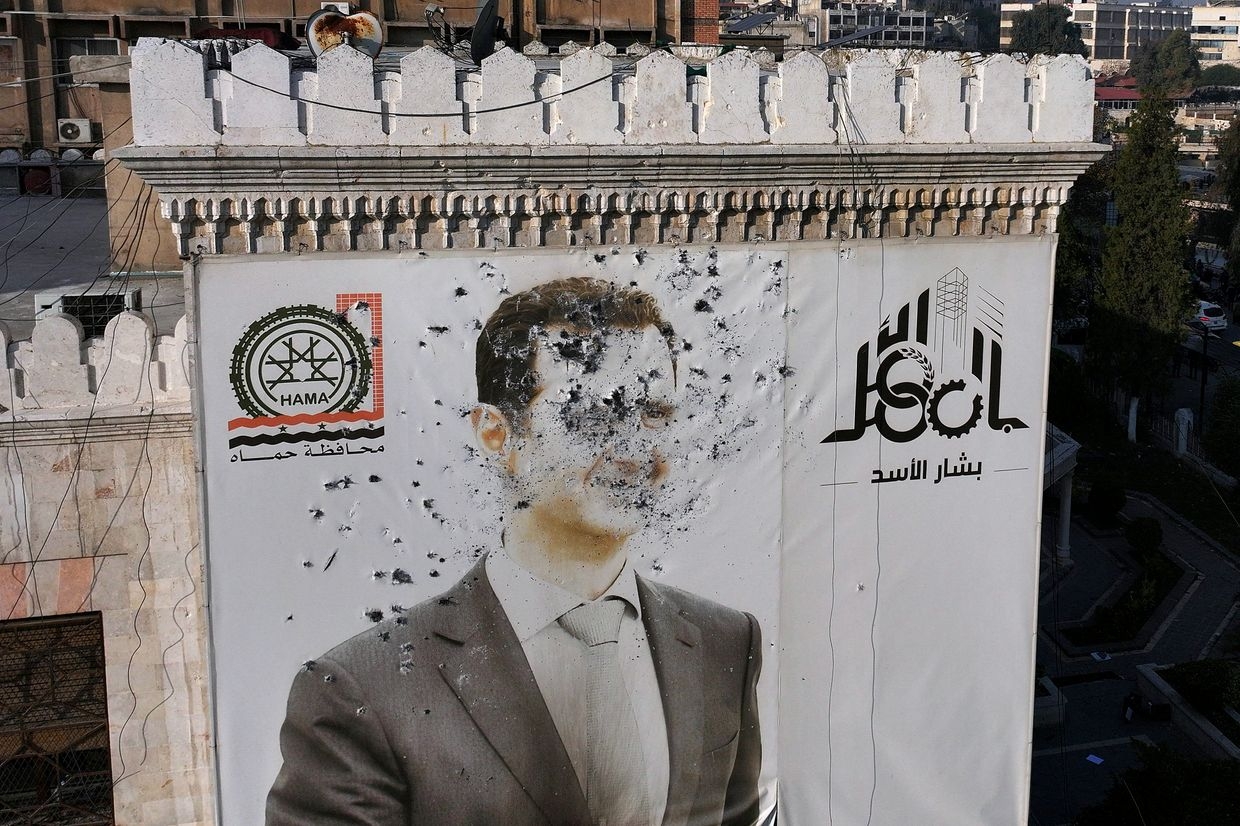 A bullet-riddled portrait of Syrian President Bashar al-Assad adorns Hama’s municipality building after it was defaced following the capture of the city by anti-government fighters in Hama, Syria, on Dec. 6, 2024.