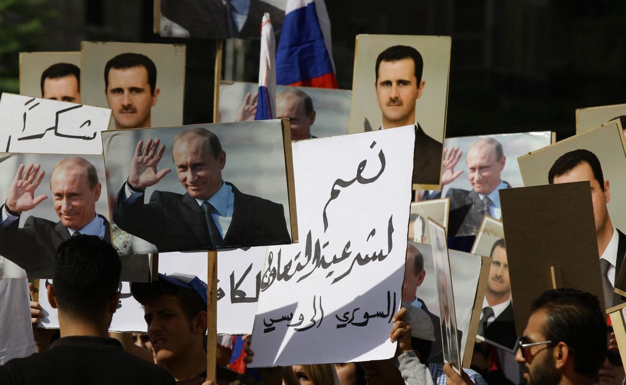 Several hundred people, holding up portraits of Syrian President Bashar al-Assad and his Russian counterpart Vladimir Putin (L), gather near the Russian embassy in Damascus, Syria on Oct.13, 2015