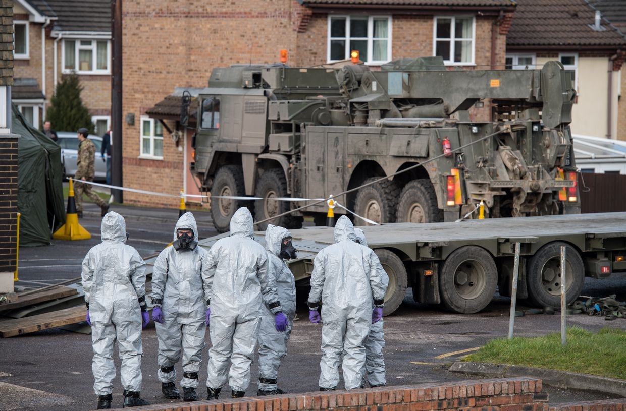 Military personnel in protective suits cover two ambulances with tarpaulin before removing them from Salisbury ambulance station in Salisbury, England, on March 10, 2018.