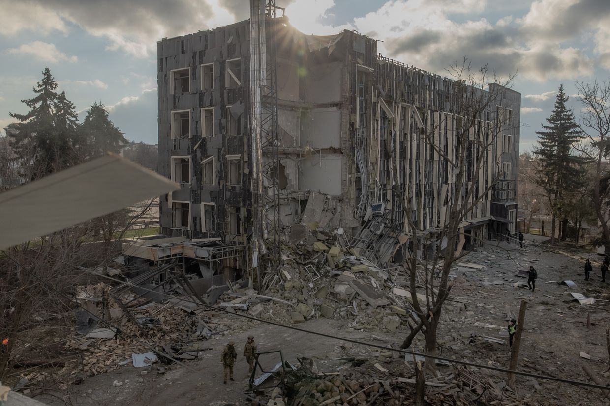 Ukrainian soldiers inspect a building in Izium damaged by a missile attack.