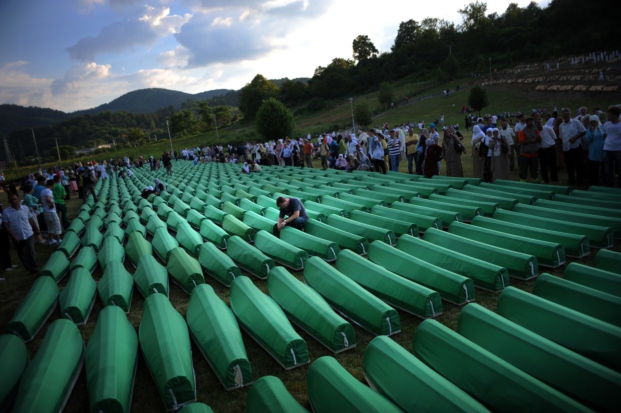 Bosnians mourn over coffins of Srebrenica massacre victims during preparations for a mass burial in Potocari, near Srebrenica, Bosnia and Herzegovina on July 10, 2010.