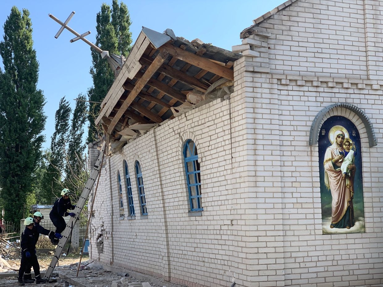 Rescuers climb a ladder outside a destroyed church after a Russian missile strike in Zaporizhzhia, Ukraine, on Aug. 10, 2023. 