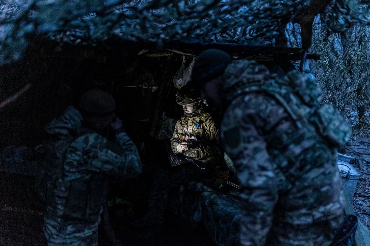 A Ukrainian soldier uses a computer next to a shelter at a frontline position near Bakhmut, Donetsk Oblast, Ukraine, on Nov. 18, 2023.
