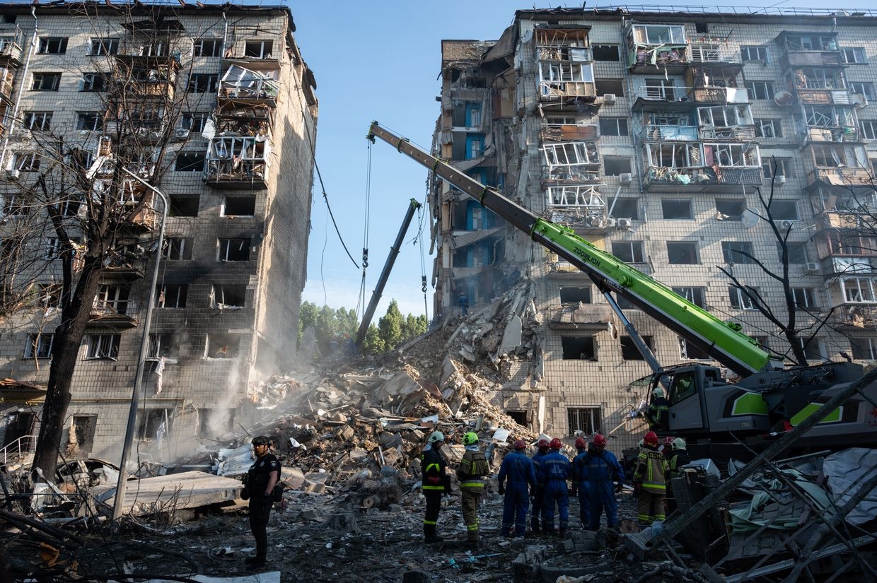People walk near a residential building damaged by a Russian attack in Kyiv, Ukraine, on June 17, 2025.