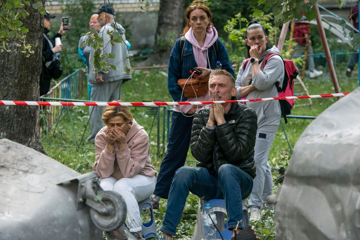 Family members of those still missing under the debris gather at the site of a residential building hit by a Russian ballistic missile in Kyiv, Ukraine, on June 17, 2025. 