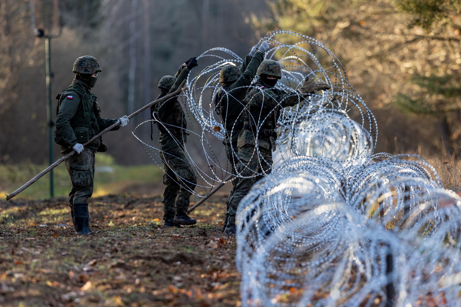Soldiers of the Polish army install concertina wire at the border with the Russian exclave Kaliningrad in Goldap, Poland, on Nov. 14, 2022. 