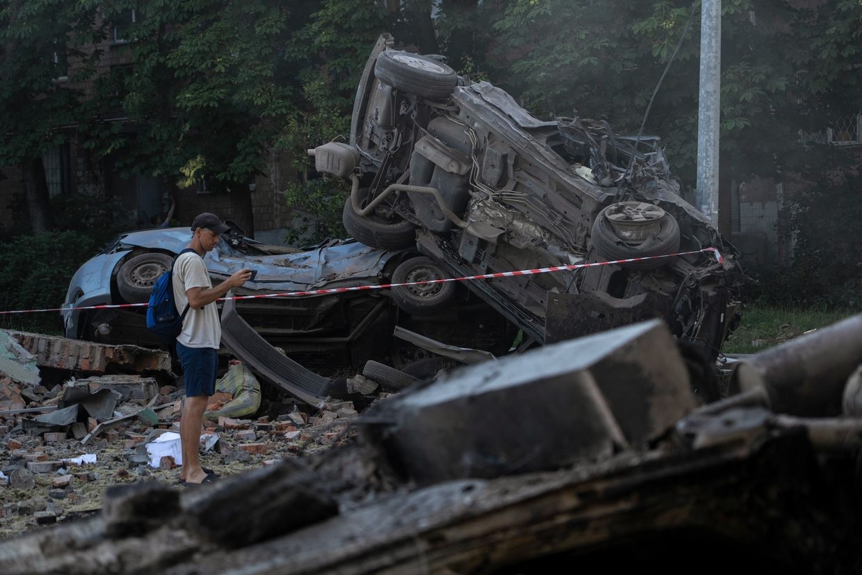 A man looks at the wreckage of cars in Kyiv, Ukraine, on July 4, 2025, after mass Russian drone and missile strikes.