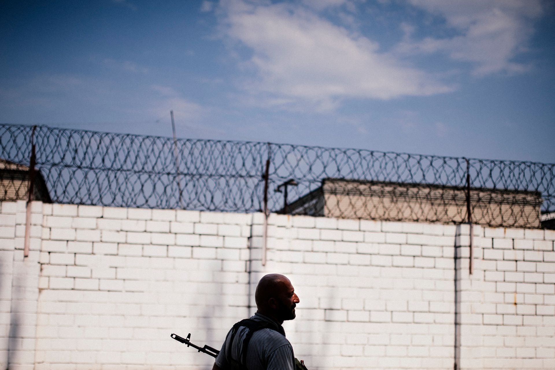 A gunman patrols the yard of a high-security prison after shelling in Donetsk, Ukraine, on Aug. 11, 2014.