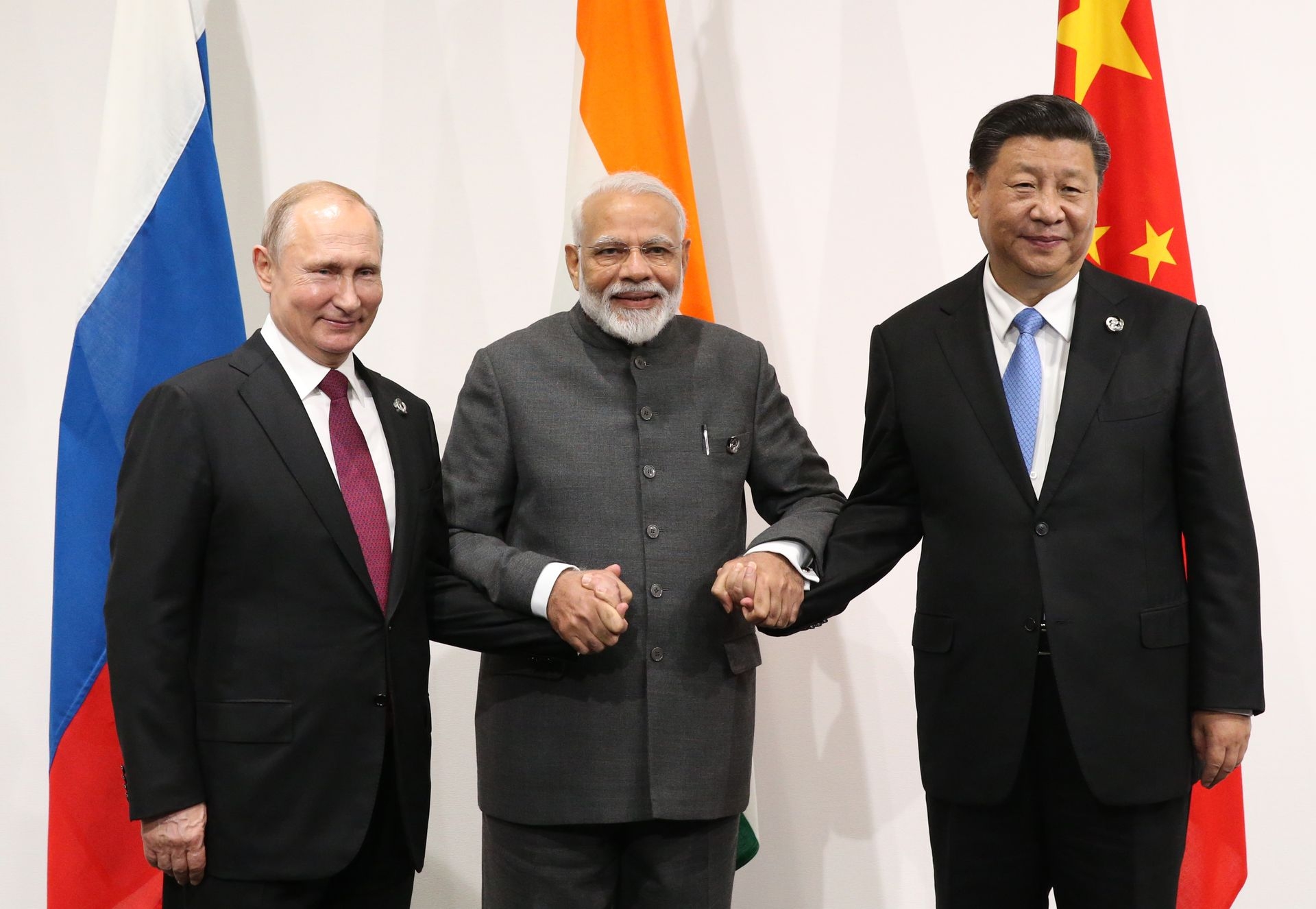 Russian President Vladimir Putin (L), Indian Prime Minister Narendra Modi (C), and Chinese President Xi Jinping (R) pose for a group photo before their trilateral meeting at the G20 Osaka Summit in Osaka, Japan, on June 28, 2019. 
