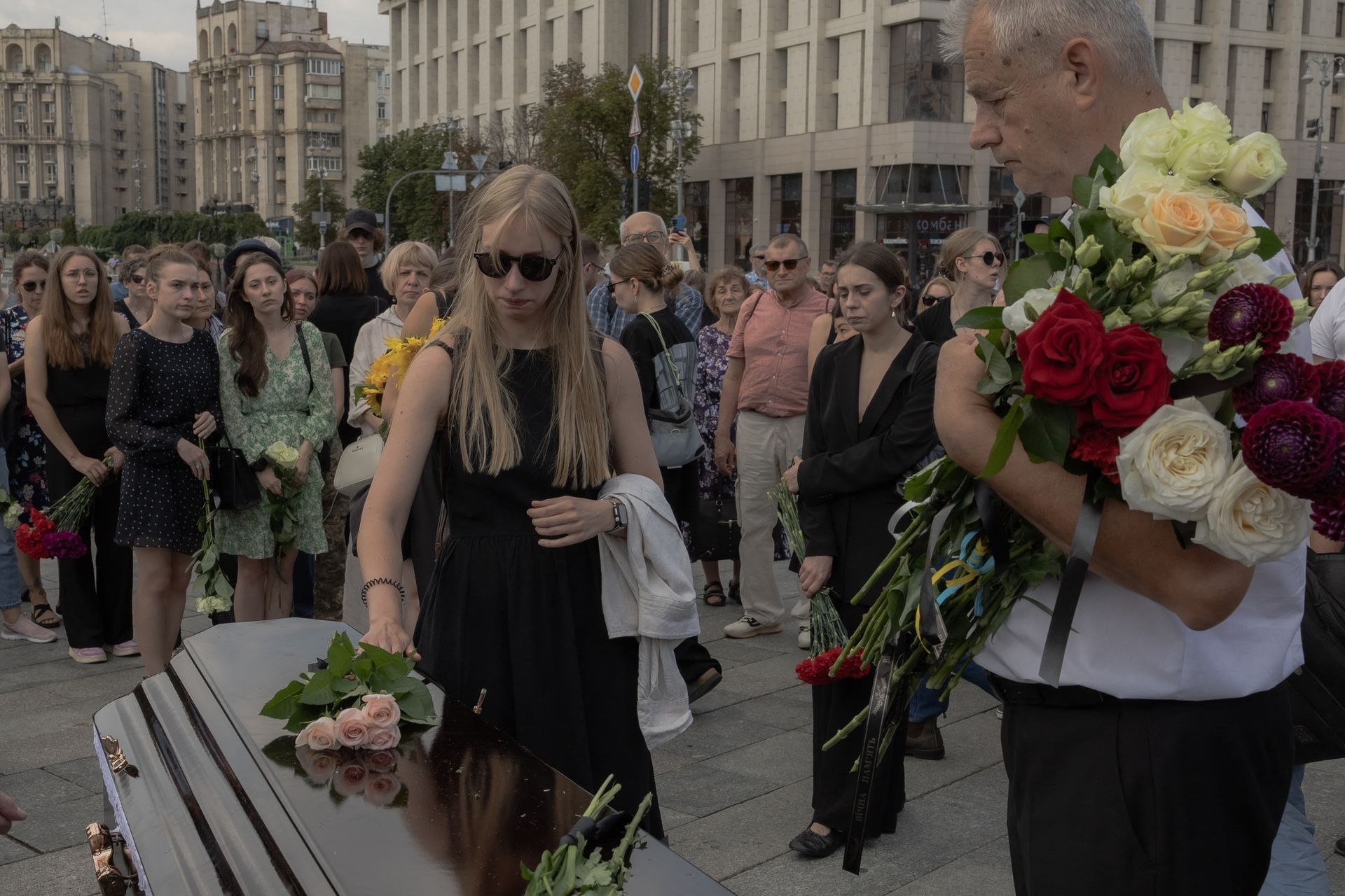 People mourn at the coffin of Victoria Roshchyna, a Ukrainian journalist who died while in Russian captivity, during her funeral ceremony in Kyiv, Ukraine, on Aug. 8, 2025. 