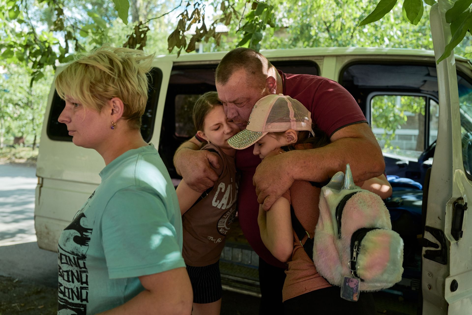 Relatives embrace in farewell as staff from the evacuation organization East SOS evacuate residents from Dobropillia, Ukraine, on Aug. 12, 2025.