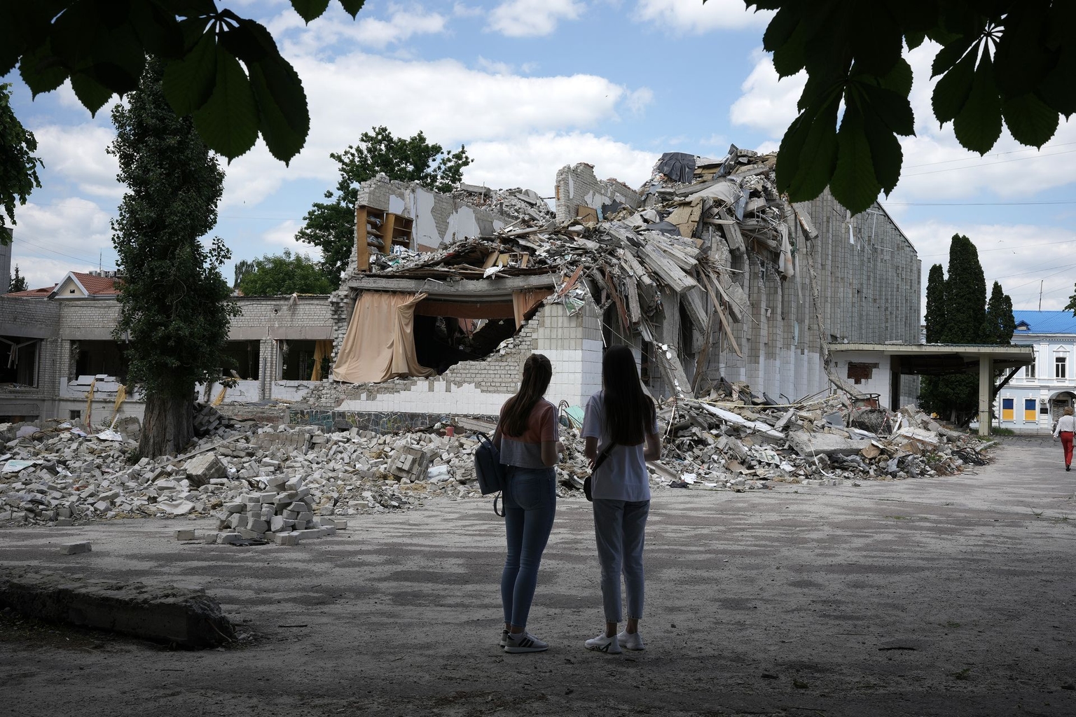 Two girls look at the remains of the bomb-destroyed Lyceum No. 25 in Zhytomyr, Ukraine, on June 7, 2022. 