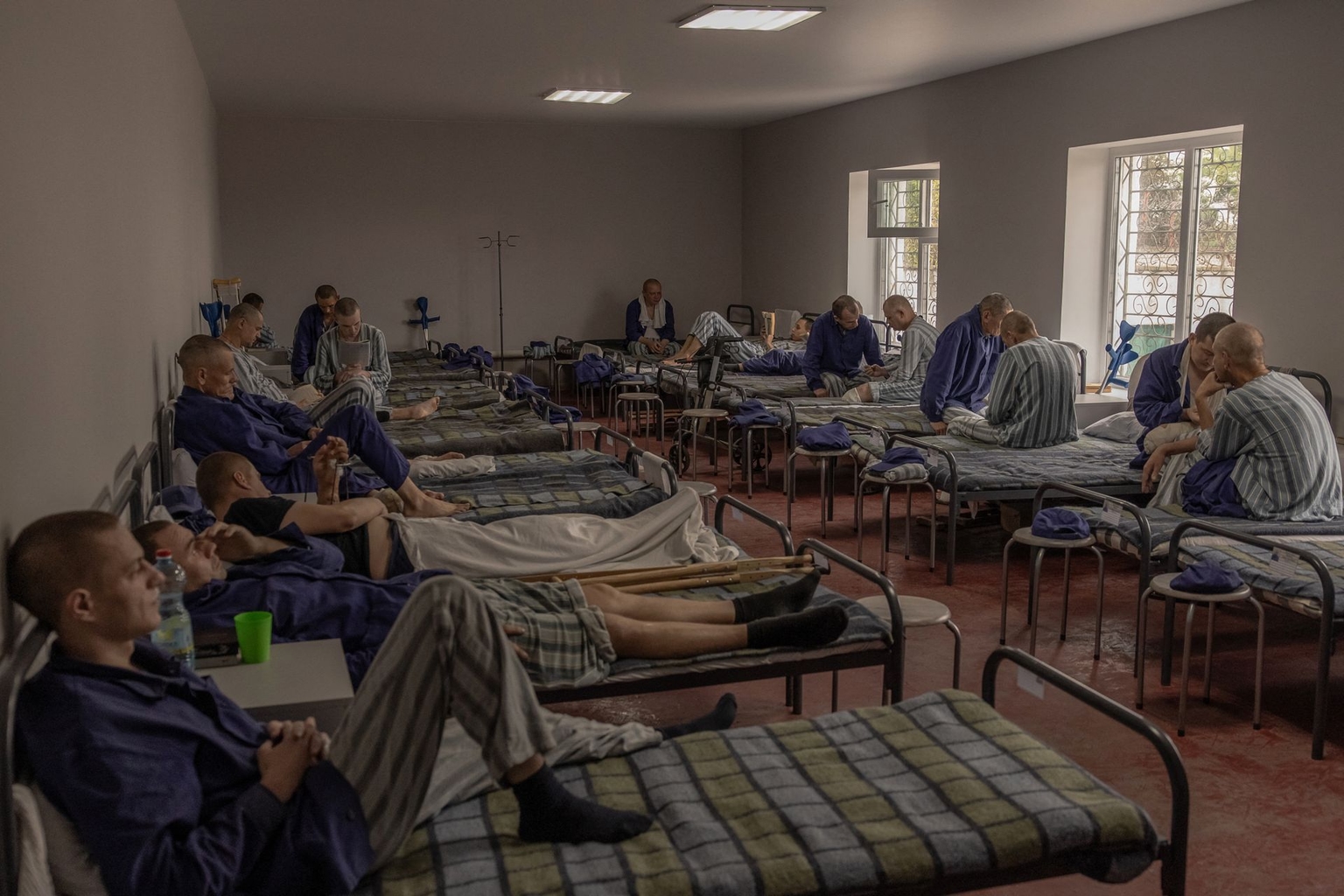 Injured Russian prisoners of war sit and lie on their beds at a camp for Russian POWs in western Ukraine on Sept. 19, 2023.