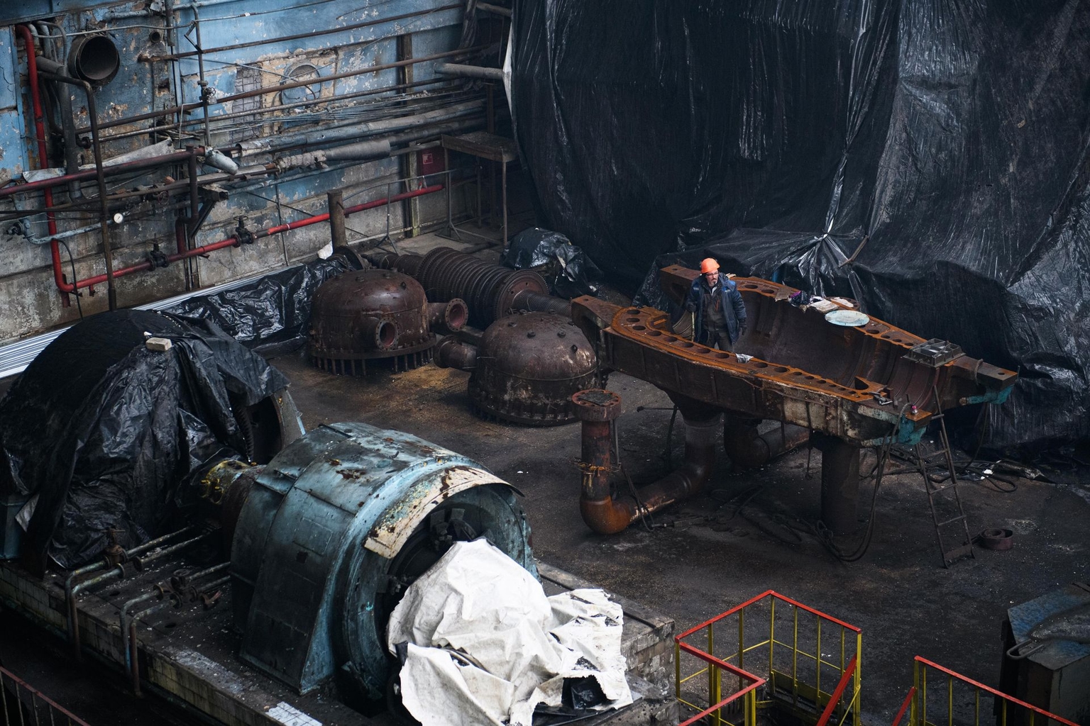 A worker stands near electrical equipment at a DTEK thermal power plant damaged by Russian missile attacks at an undisclosed location in Ukraine on Nov. 28, 2024. 