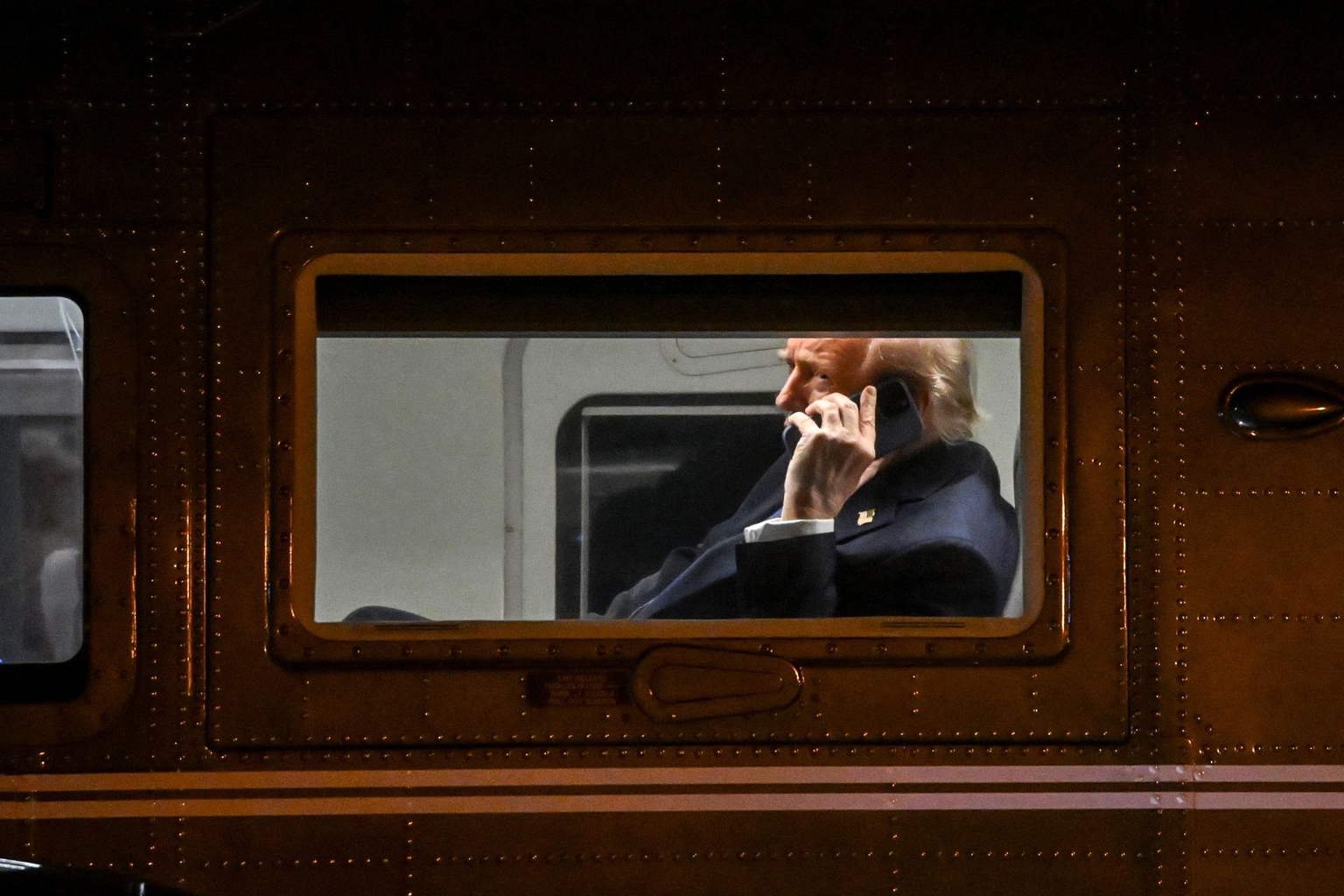 U.S. President Donald Trump uses a cellphone aboard Marine One before departing Leesburg Executive Airport in Leesburg, Virginia, U.S. on April 24, 2025. 