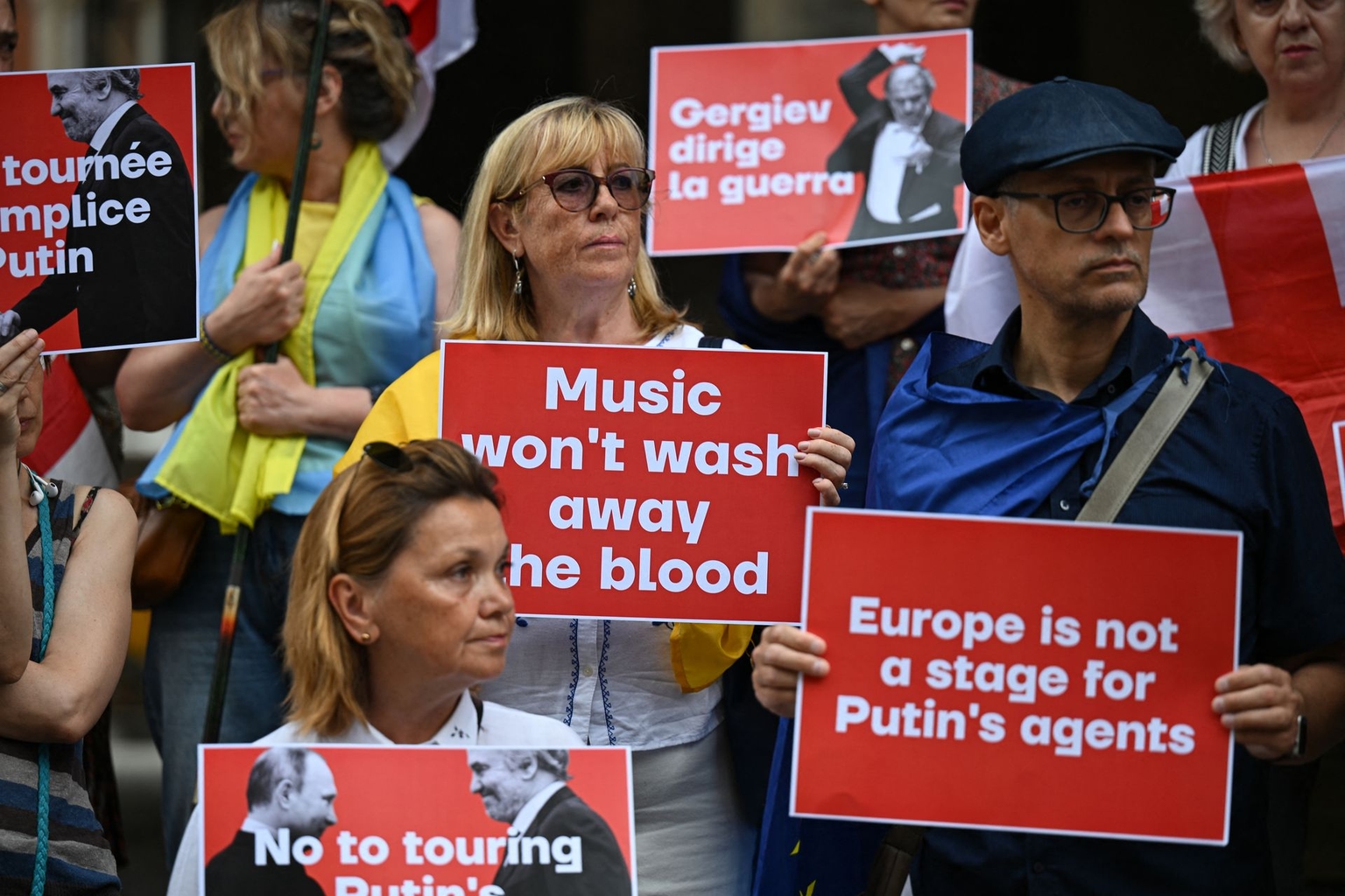 People hold placards during a protest against the planned appearance of Russian conductor Valery Gergiev at an event at the Reggia di Caserta on July 27 in Milan, Italy, on July 19, 2025. 
