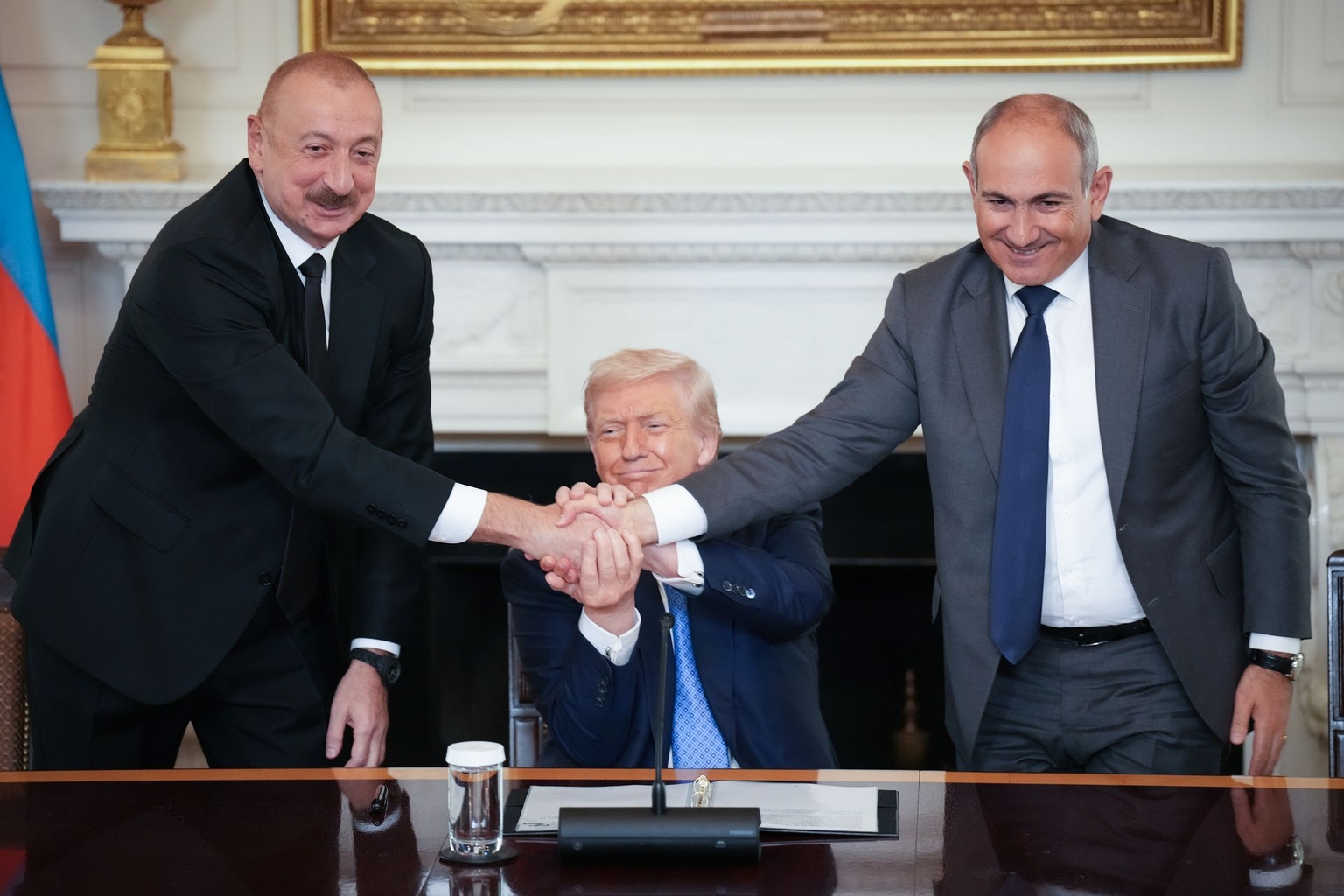 U.S. President Donald Trump (C) joins hands with Azerbaijani President Ilham Aliyev (L) and Armenian Prime Minister Nikol Pashinyan (R) during a signing ceremony in the State Dining Room of the White House in Washington, D.C., U.S. on Aug. 8, 2025.
