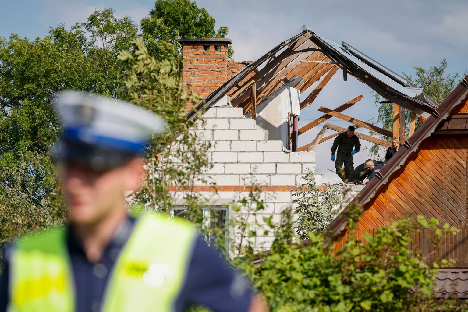 Police and soldiers inspect damage to a house destroyed by debris from a Russian drone shot down in Wyryki-Wola, Poland, on Sept. 10, 2025. 