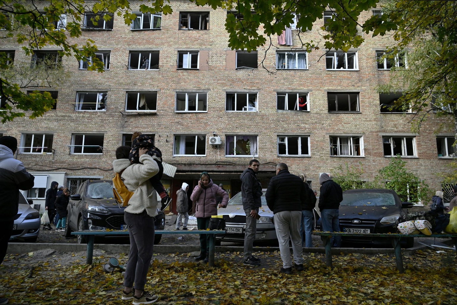 Residents look at a residential building damaged by a massive drone and missile strike on Kyiv, Ukraine, on Oct. 22, 2025. 