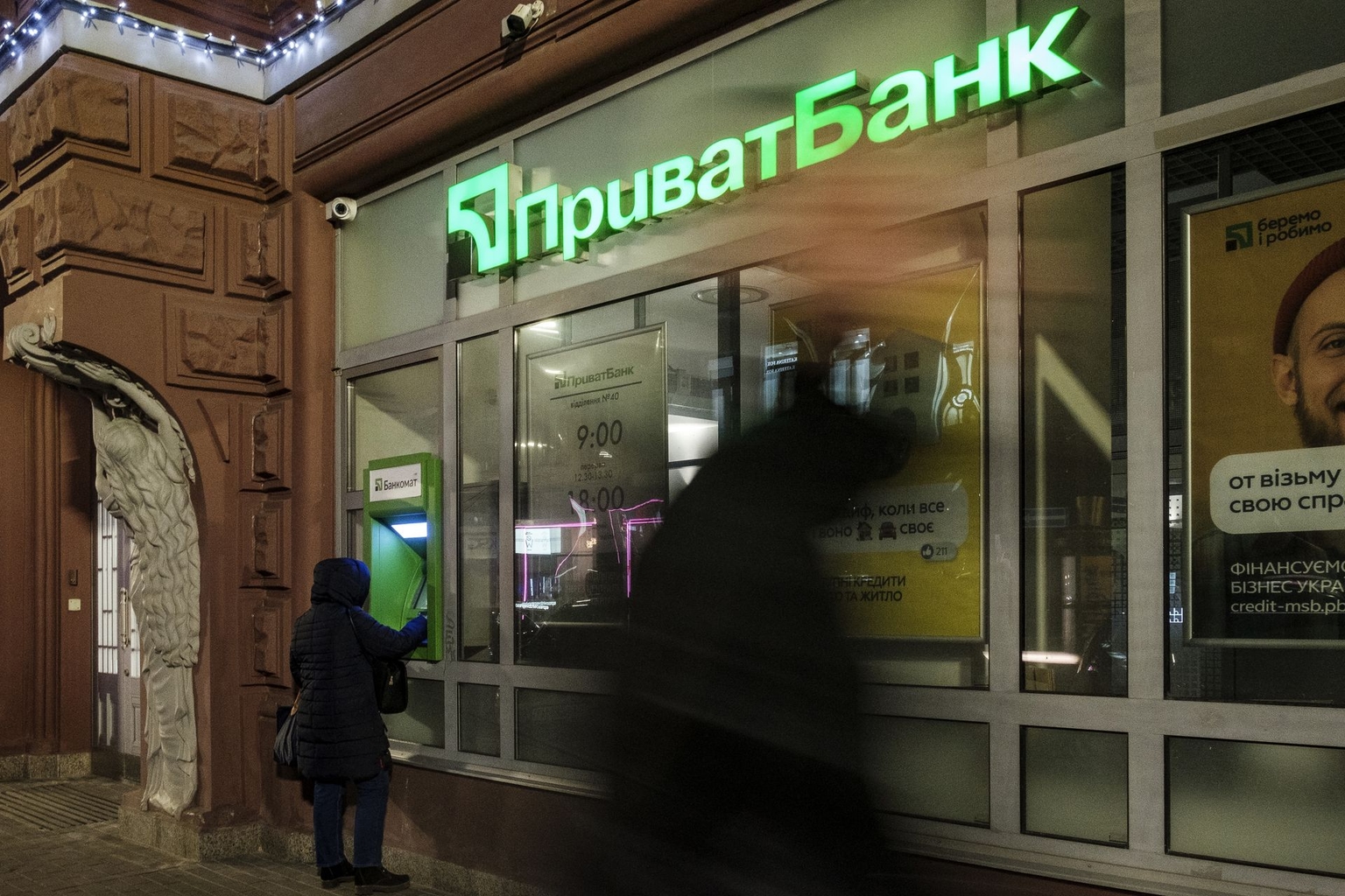 A customer uses an ATM at a PrivatBank branch in Kyiv, Ukraine, on Feb. 22, 2022. 