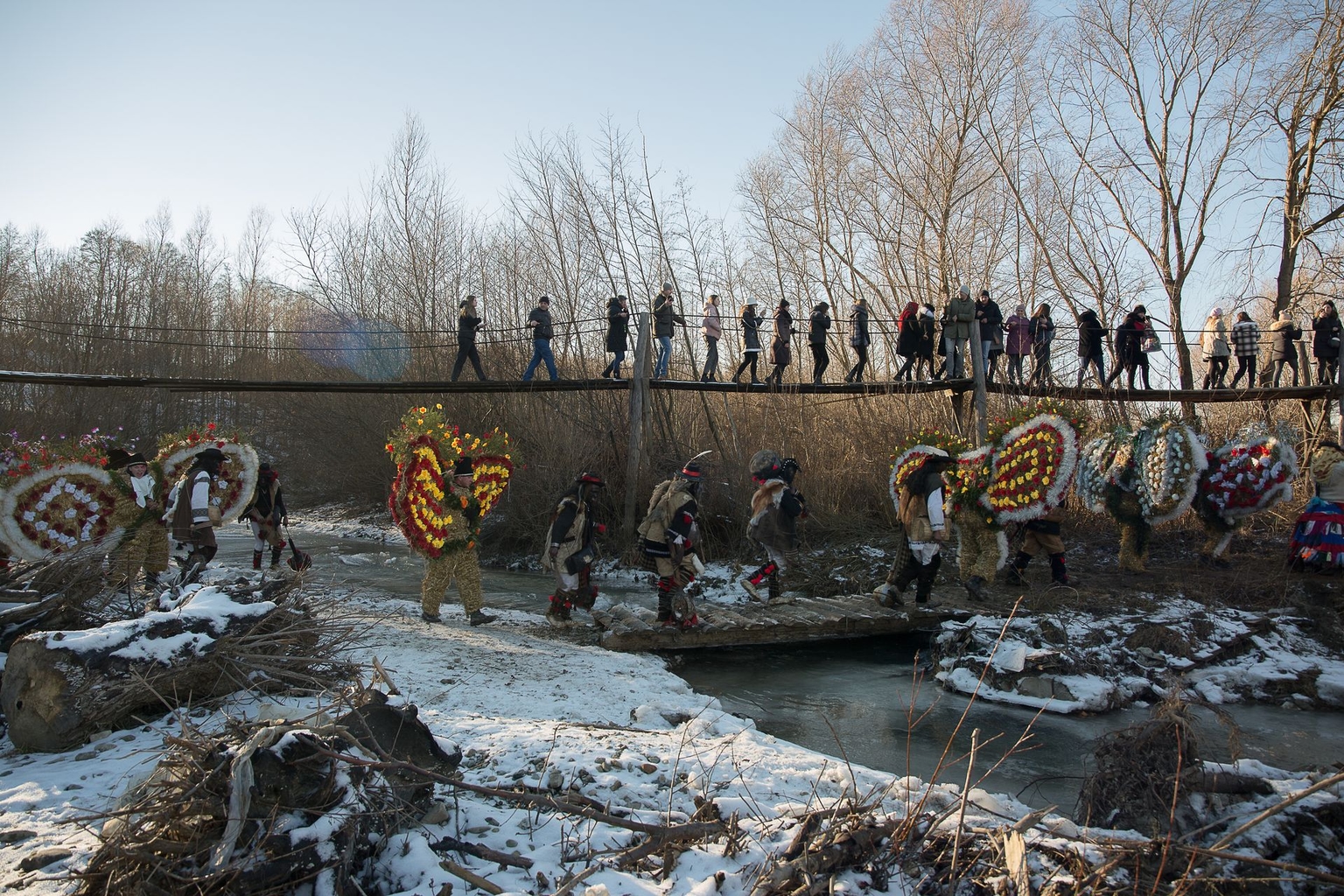 A procession crosses a bridge during Malanka celebrations in Krasnoilsk, Chernivtsi Oblast, Ukraine, on Jan. 14, 2022.