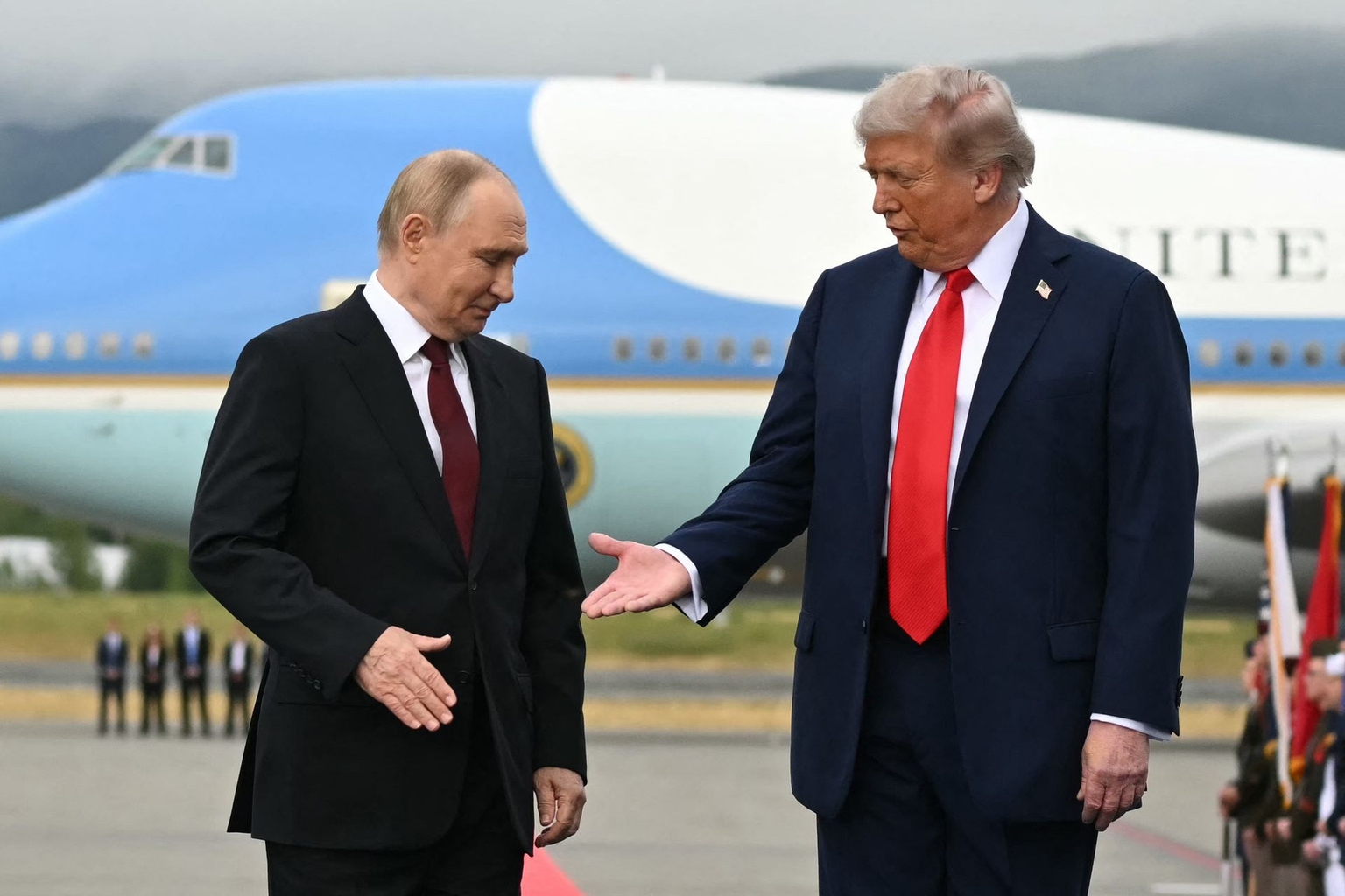 U.S. President Donald Trump (R) reaches out to shake hands with Russian President Vladimir Putin (L) as they pose on the tarmac at Joint Base Elmendorf–Richardson during Putin’s visit to Alaska, his first trip to a Western country since Russia launched its full-scale invasion of Ukraine.