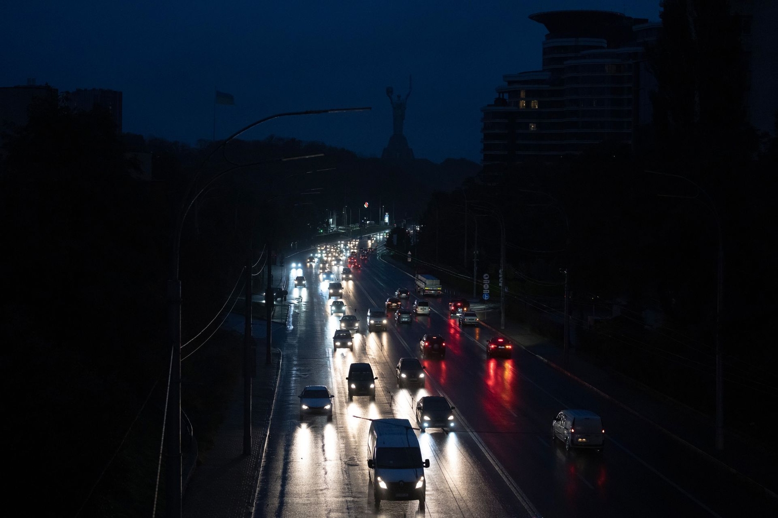 Vehicle lights illuminate a highway during a blackout after a power loss in Kyiv, following a massive Russian drone and missile attack that disrupted electricity and water supply in parts of the capital.