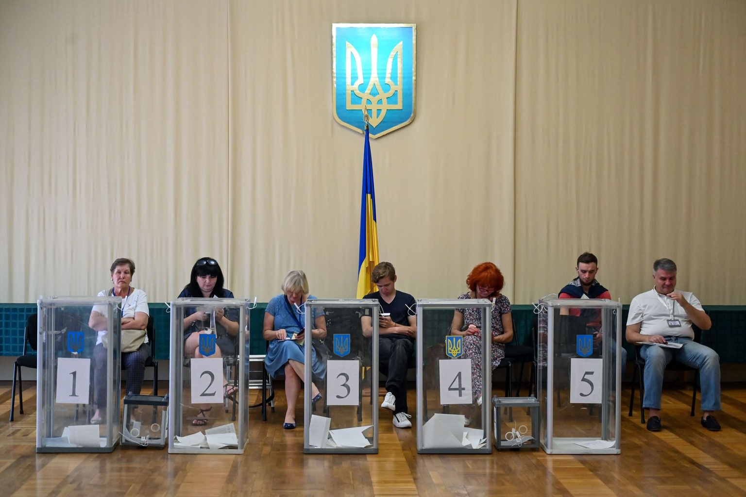Observers sit behind ballot boxes at a polling station during Ukraine’s parliamentary election in Kyiv, Ukraine, on July 21, 2019. 