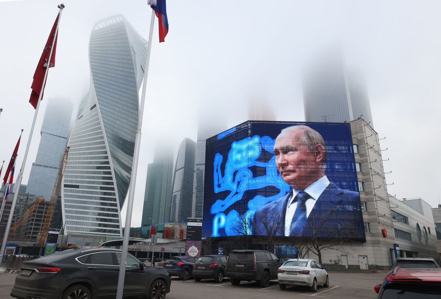 Russian President Vladimir Putin is shown on a screen mounted on an office building against the backdrop of Moscow City's skyscrapers in Moscow, Russia, on Dec. 1, 2025. 