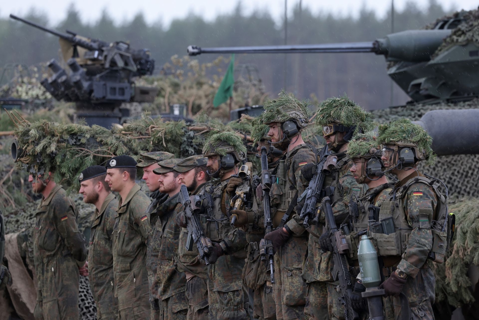 Troops of the German armed forces stand near their vehicles during the Quadriga military exercises near Pabrade, Lithuania, on May 29, 2024.