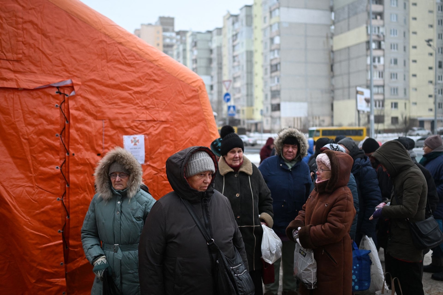 Local residents gather to receive hot meals distributed by volunteers in a residential area of Kyiv, Ukraine, left without electricity and water after recent Russian strikes battered the energy sector, on Jan. 22, 2026. 