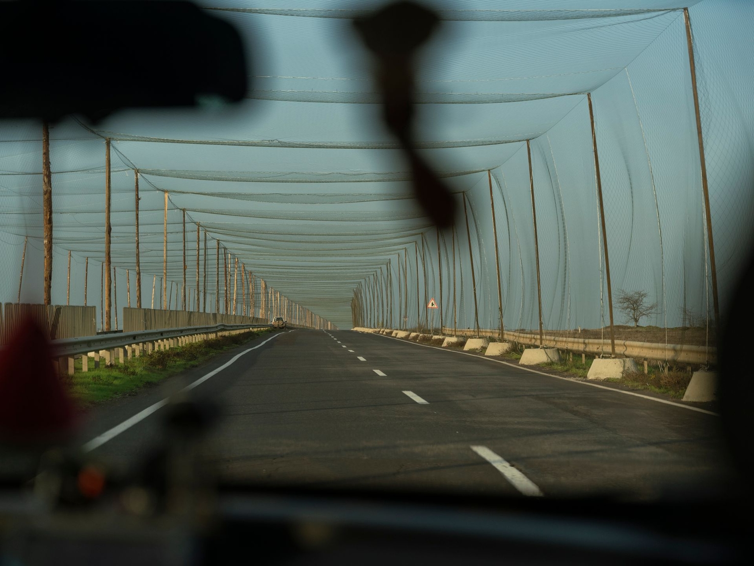 Highway covered end-to-end by a continuous tunnel of anti-drone nets on the road to Kherson, Ukraine, on Nov. 21, 2025.