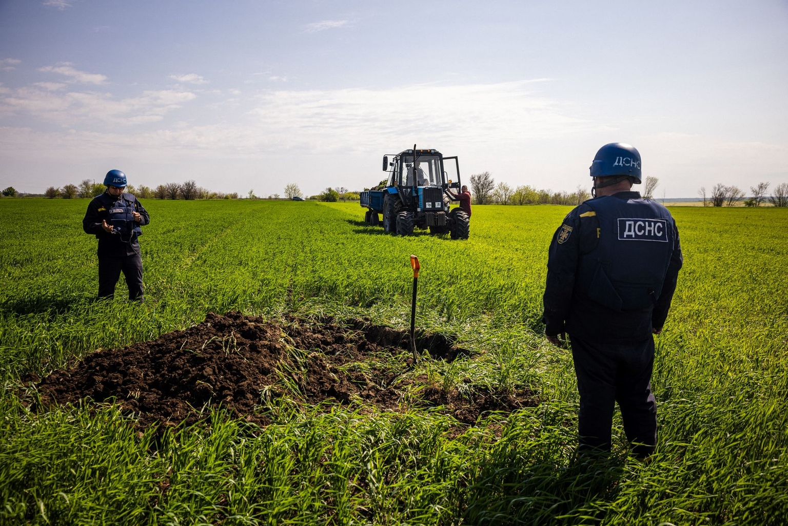 Members of a demining team of the State Emergency Service of Ukraine prepare to destroy an unexploded missile near the village of Hryhorivka, Zaporizhzhia Oblast, Ukraine, on May 5, 2022.