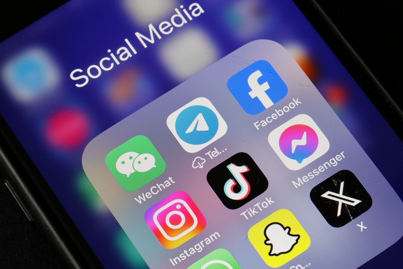 WeChat, Telegram, Facebook, Instagram, TikTok, Messenger, Snapchat, and X application logos are displayed on an iPhone's screen.