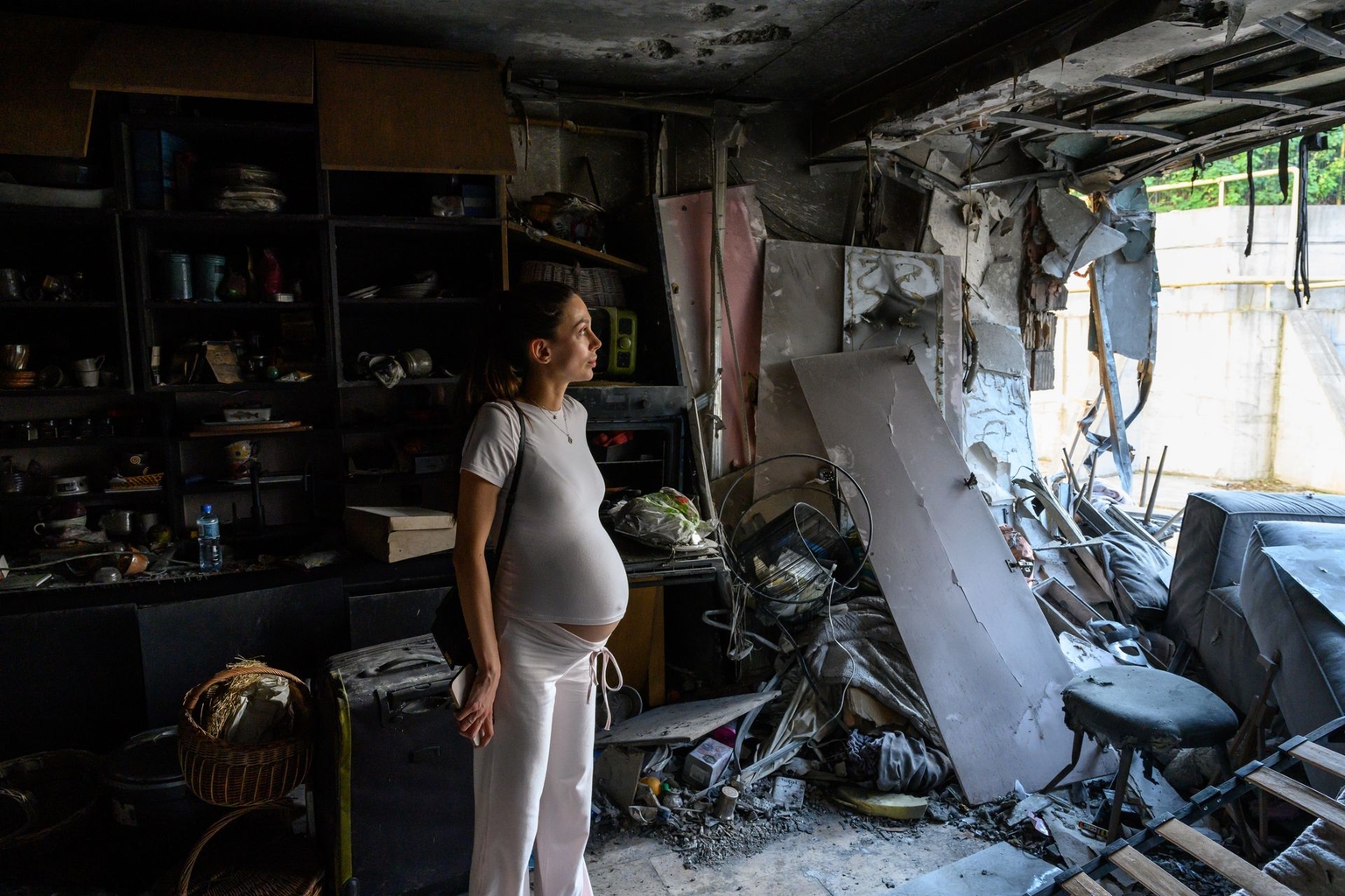 Ukrainian Bogdana Zhupanyna, in her ninth month of pregnancy, surveys damage to her apartment after it was struck by a Russian-made, Iran-designed Shahed-136 drone in Kyiv, Ukraine, on July 23, 2025.