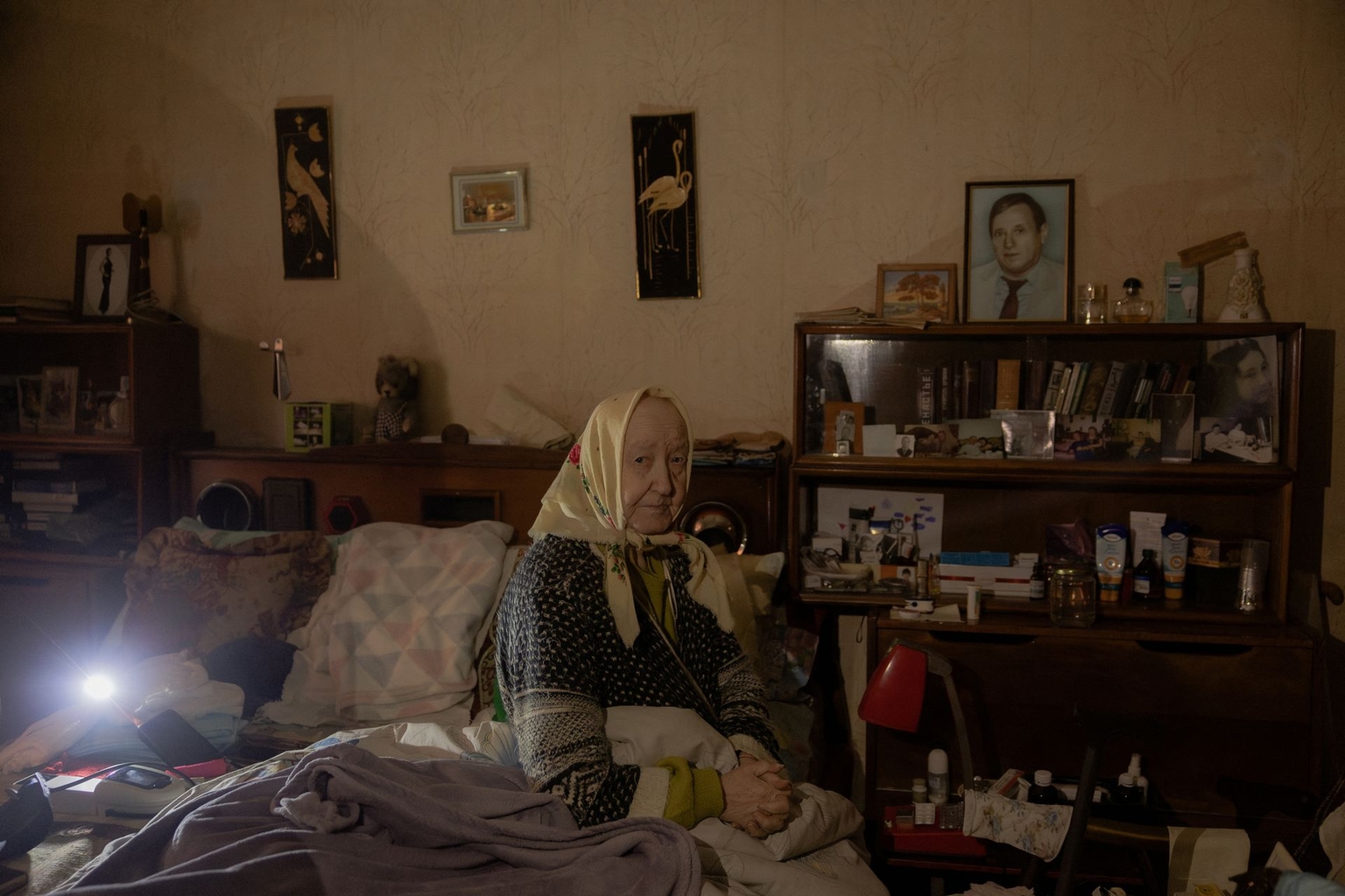 Esfir Rudminska, an 88-year-old pensioner, sits on a bed in her apartment without electricity and with little heating in Kyiv, Ukraine, on Jan. 26, 2026.