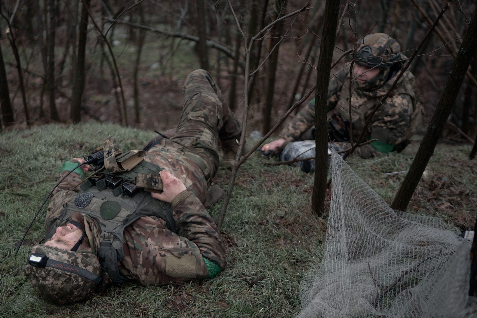 Two wounded Ukrainian soldiers from the 5th Separate Assault Brigade lie on a road between Druzhkivka and Kostiantynivka awaiting evacuation amid ongoing fighting and intensified Russian artillery and FPV drone attacks in Donetsk Oblast, Ukraine, on Feb. 13, 2026.