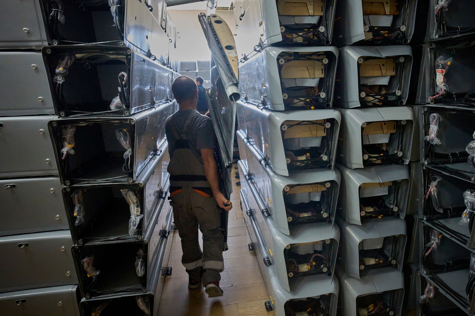 A worker carries a component of a combat drone at a Fire Point secret factory in Ukraine on Aug. 14, 2025.