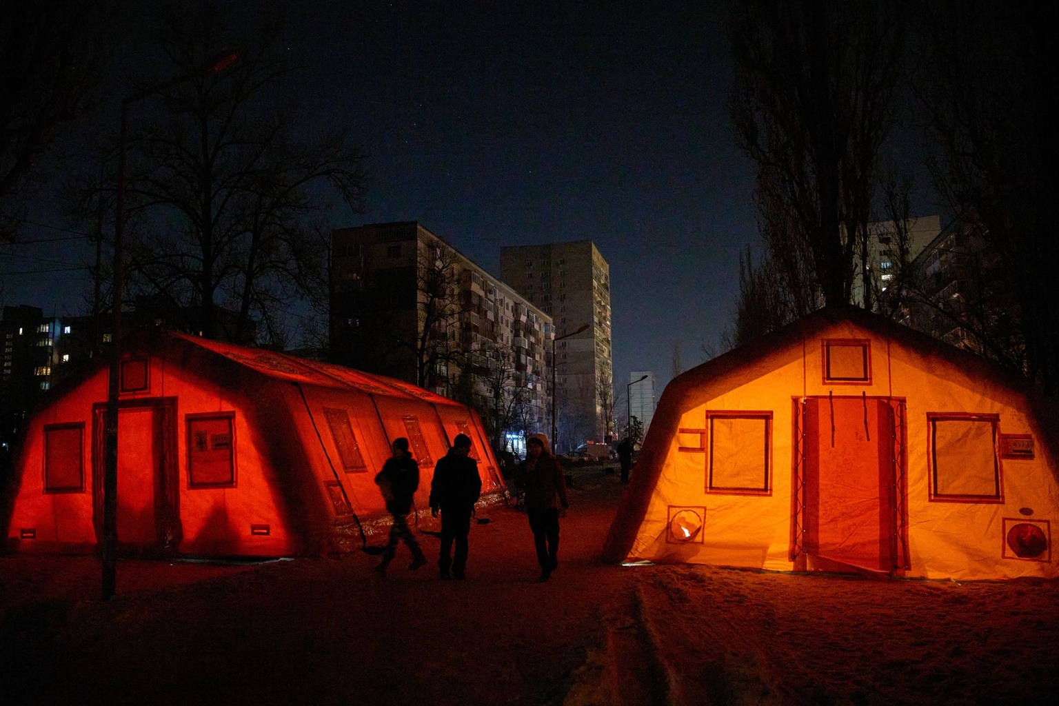 People walk past emergency warming tents in Kyiv, Ukraine, on Jan. 21, 2026. 