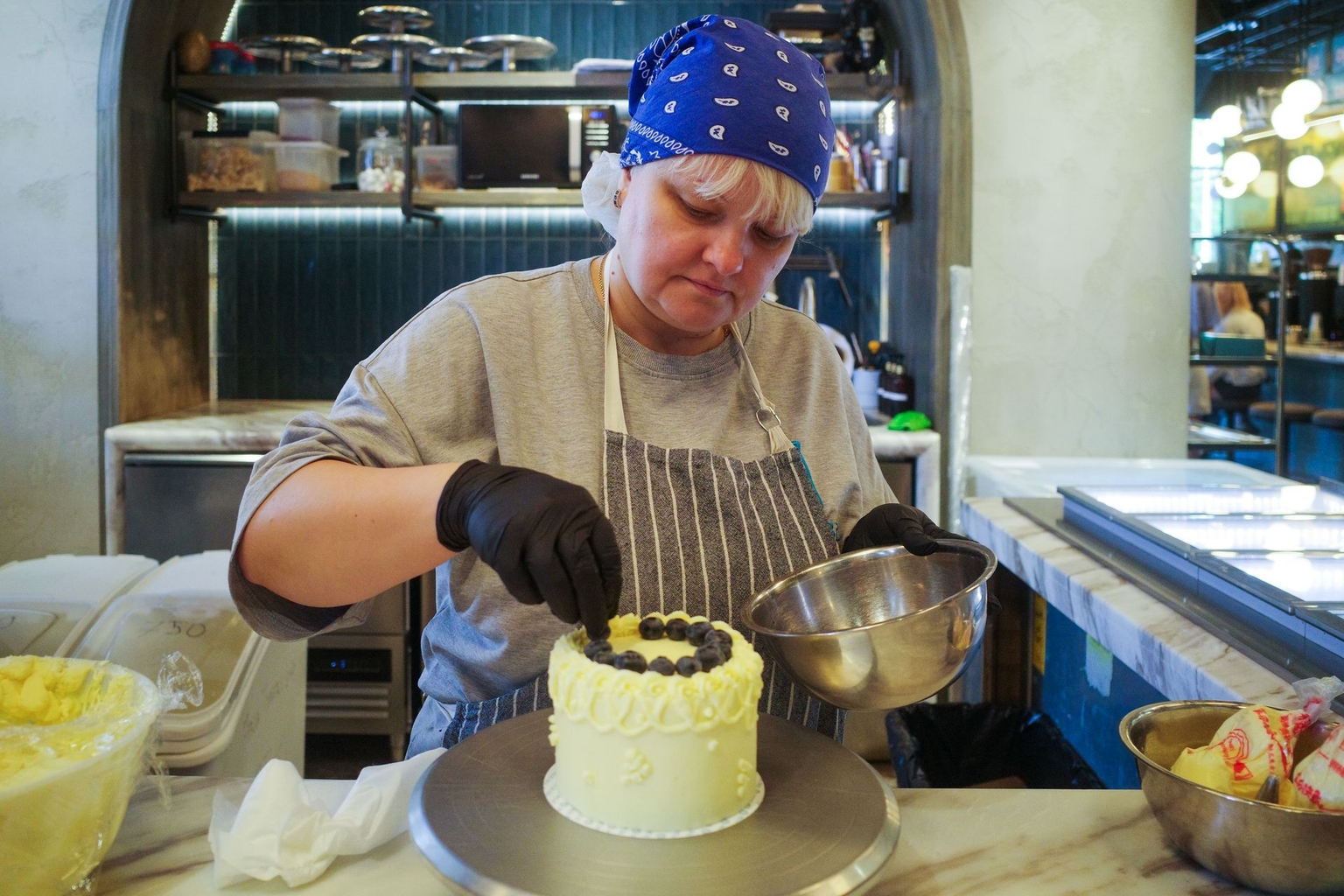 A Ukrainian woman prepares cakes in the kitchen at Milk Bar in Warsaw, Poland, on May 15, 2026.