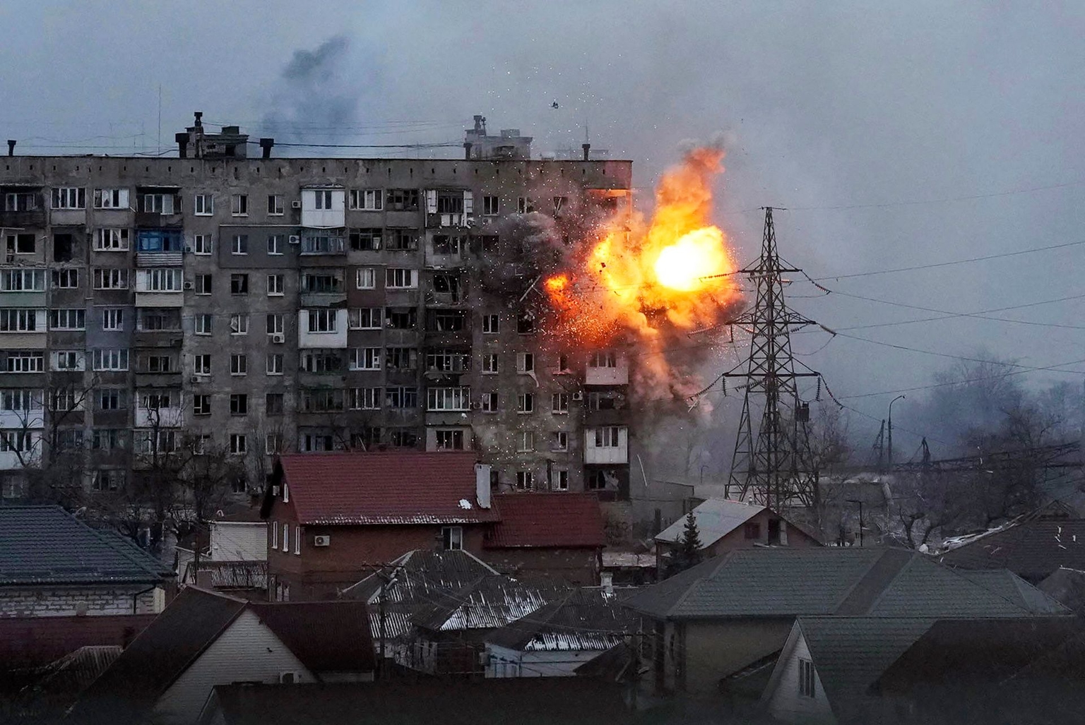 An explosion is seen in an apartment building after a Russian tank fires in Mariupol, Ukraine, on March 11, 2022.