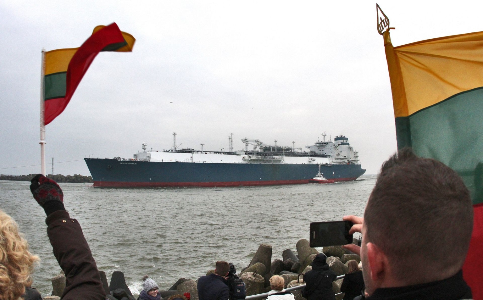 People wave flags as they welcome the LNG terminal Independence in Klaipeda, Lithuania, on October 27, 2014.