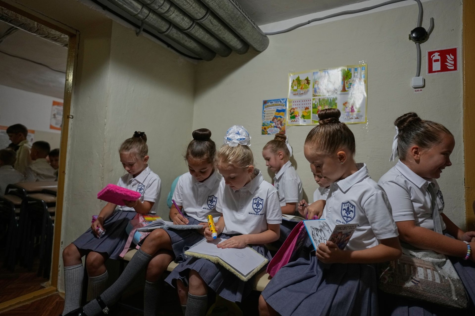 Schoolgirls work on a lesson in a bomb shelter during a Russian air attack on the first day of school at a cadet lyceum in Kyiv, Ukraine, on Sept. 1, 2026.