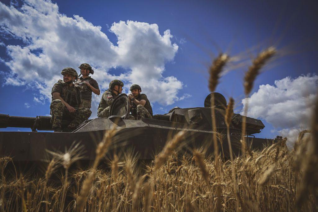 Ukrainian military personnel sit atop a Howitzer at the front line in Vuhledar